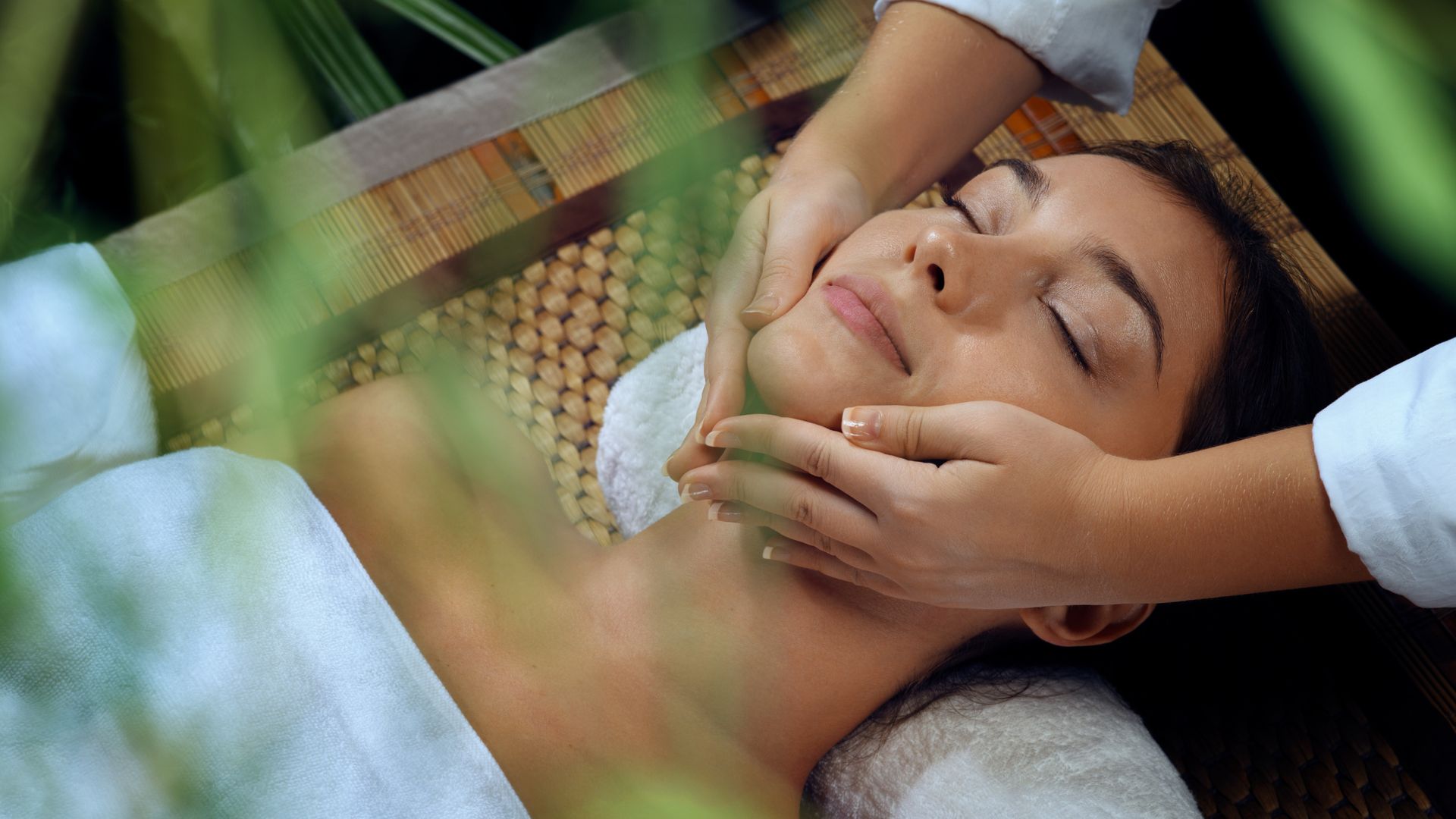 A woman getting a facial massage at a spa