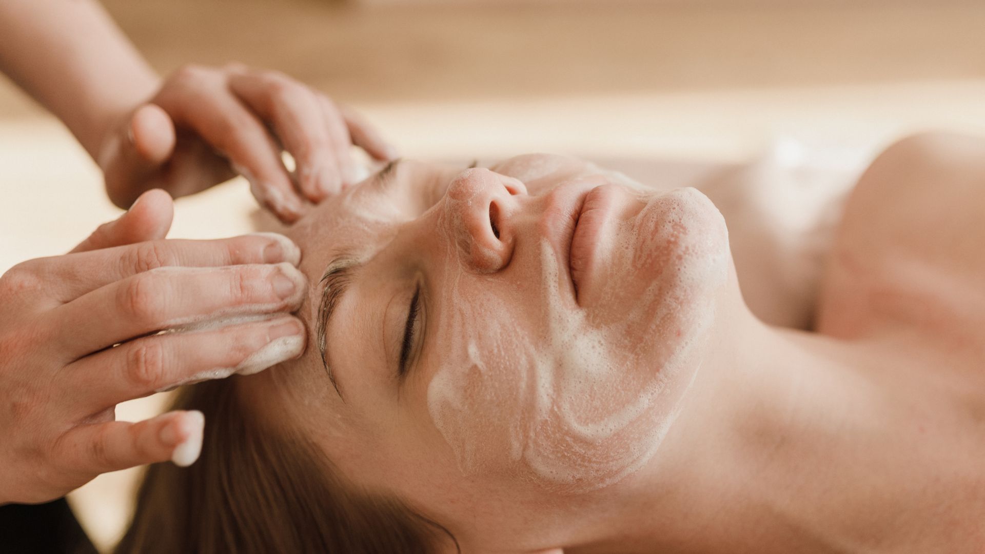 A woman getting a facial mask on her face