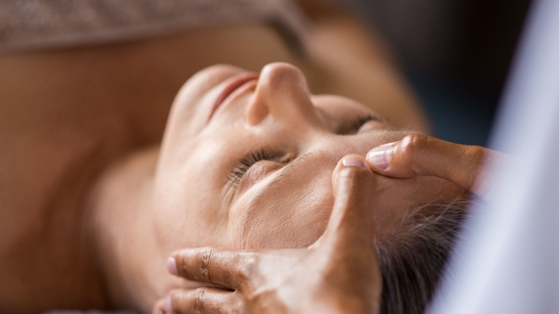 A woman getting a facial massage at a spa